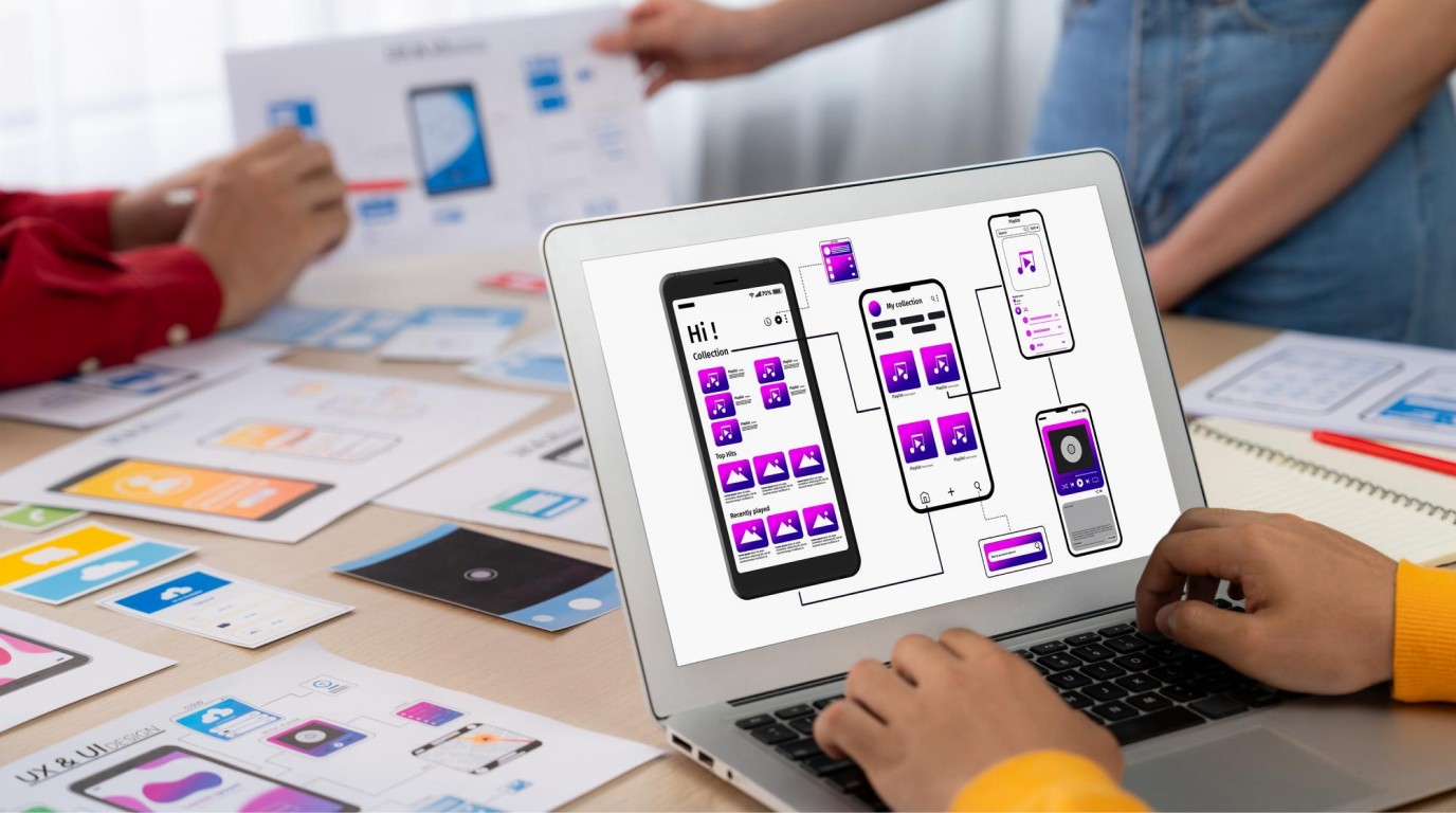 AI changing UI UX design — product team reviewing mobile app wireframes and user flow on a laptop — Penguincil Design