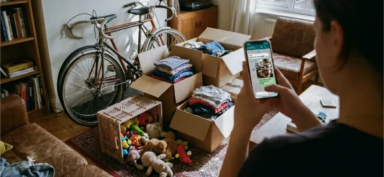 Captura de foto con celular a una bicicleta, bolsas y cajas listas para donar.