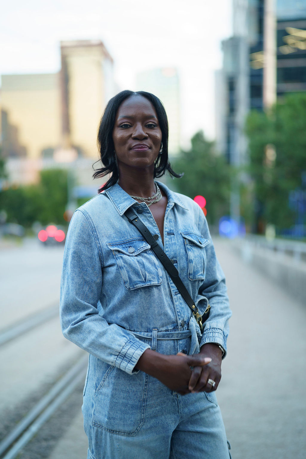 Woman in a light suit sitting thoughtfully against a terracotta wall