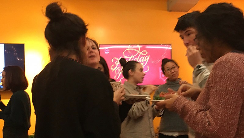 a group of people is having a snack in an exhibition room