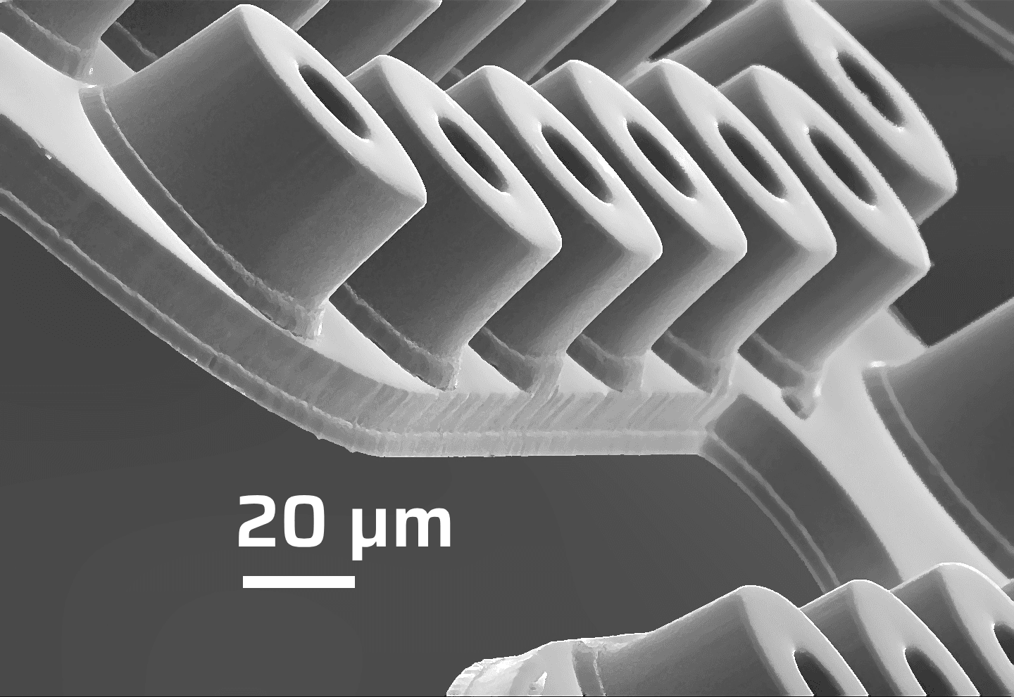 Close-up of a precision-engineered metal component with intersecting diagonal supports and fine structural detail.