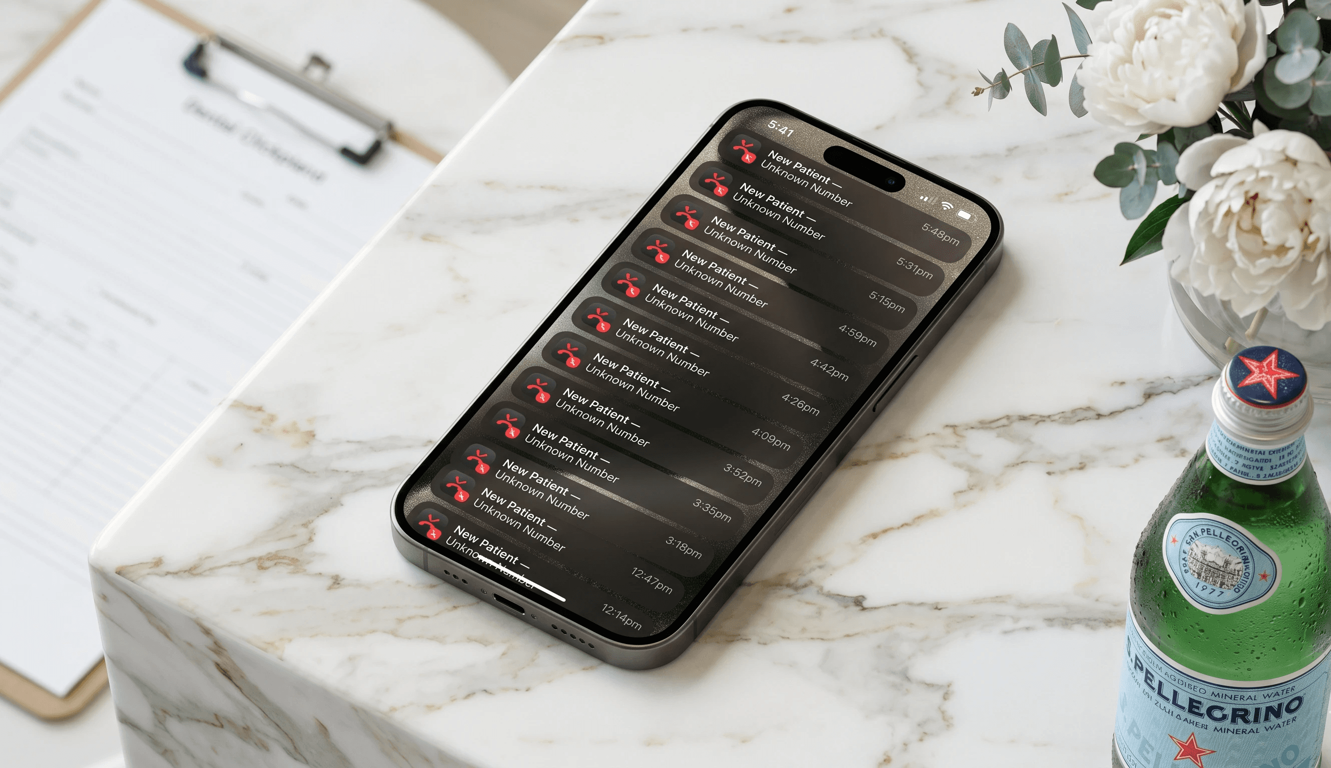 iPhone lock screen showing 12 missed patient call            notifications on a dental reception counter — represents            £350 lost per call.