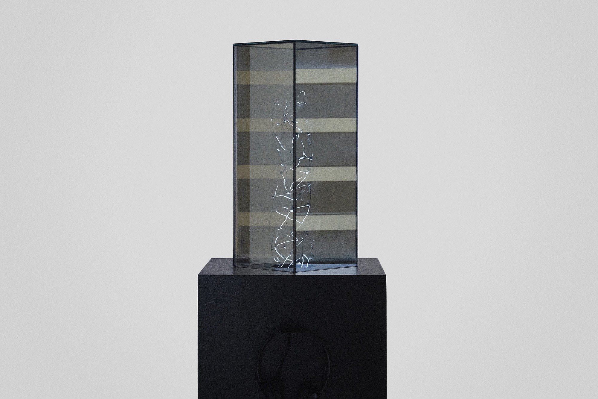 Vertical rectangular mirrored prism on a black base. Inside, a vortex light representation between parallel universes