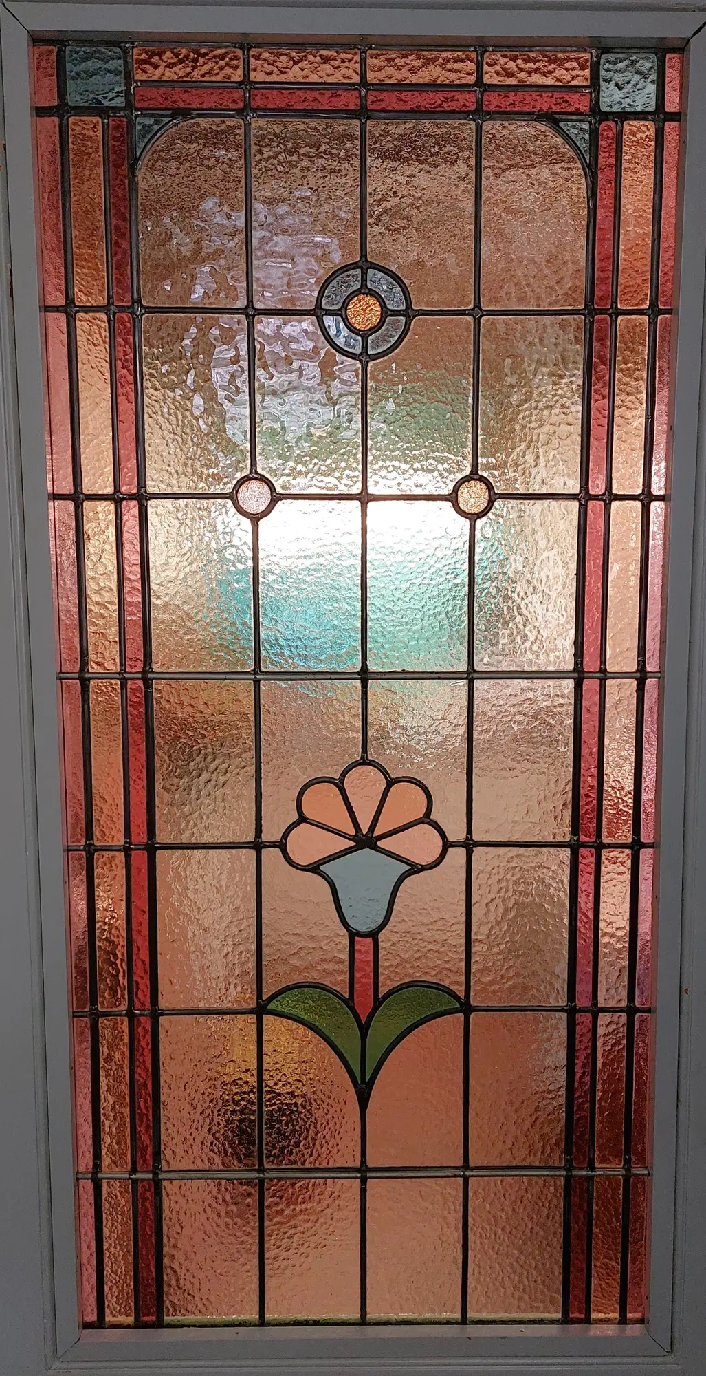 Art-Deco deurpaneel met floraal element met doorvallend licht na herstelling - Borgerhout