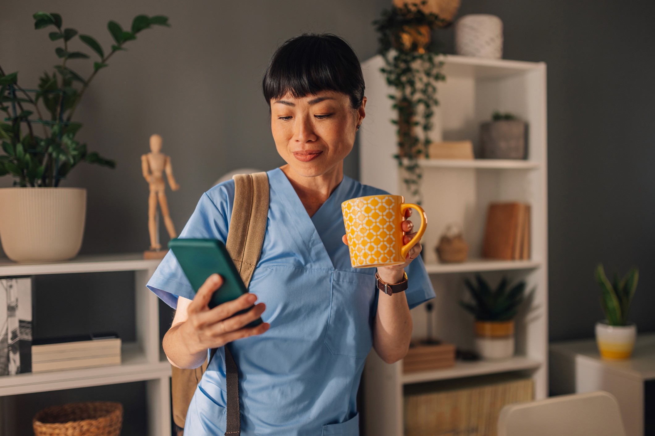 Smiling man working on a laptop at a desk, seated in front of a colorful abstract painting