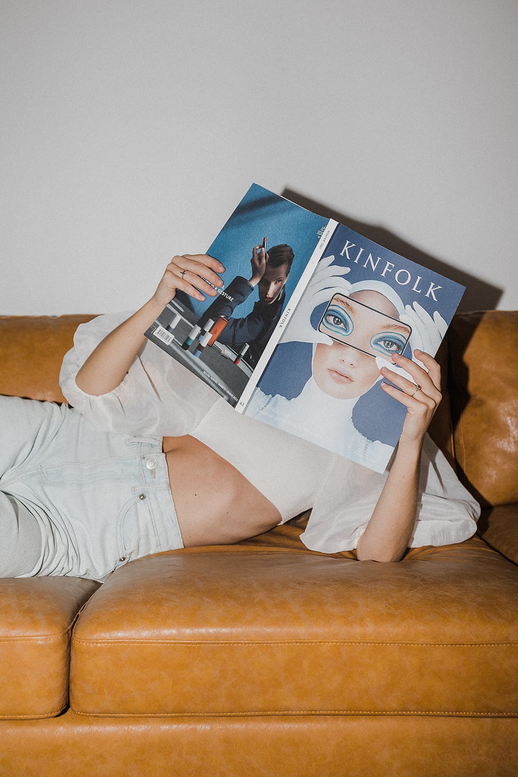 Woman on couch reading magazine