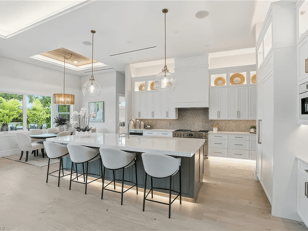 a modern kitchen with white cabinets and high ceilings
