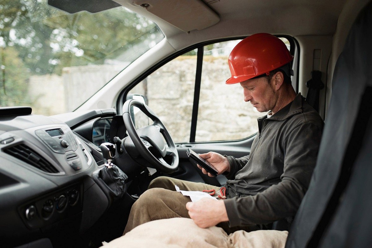 Workman doing admin in van
