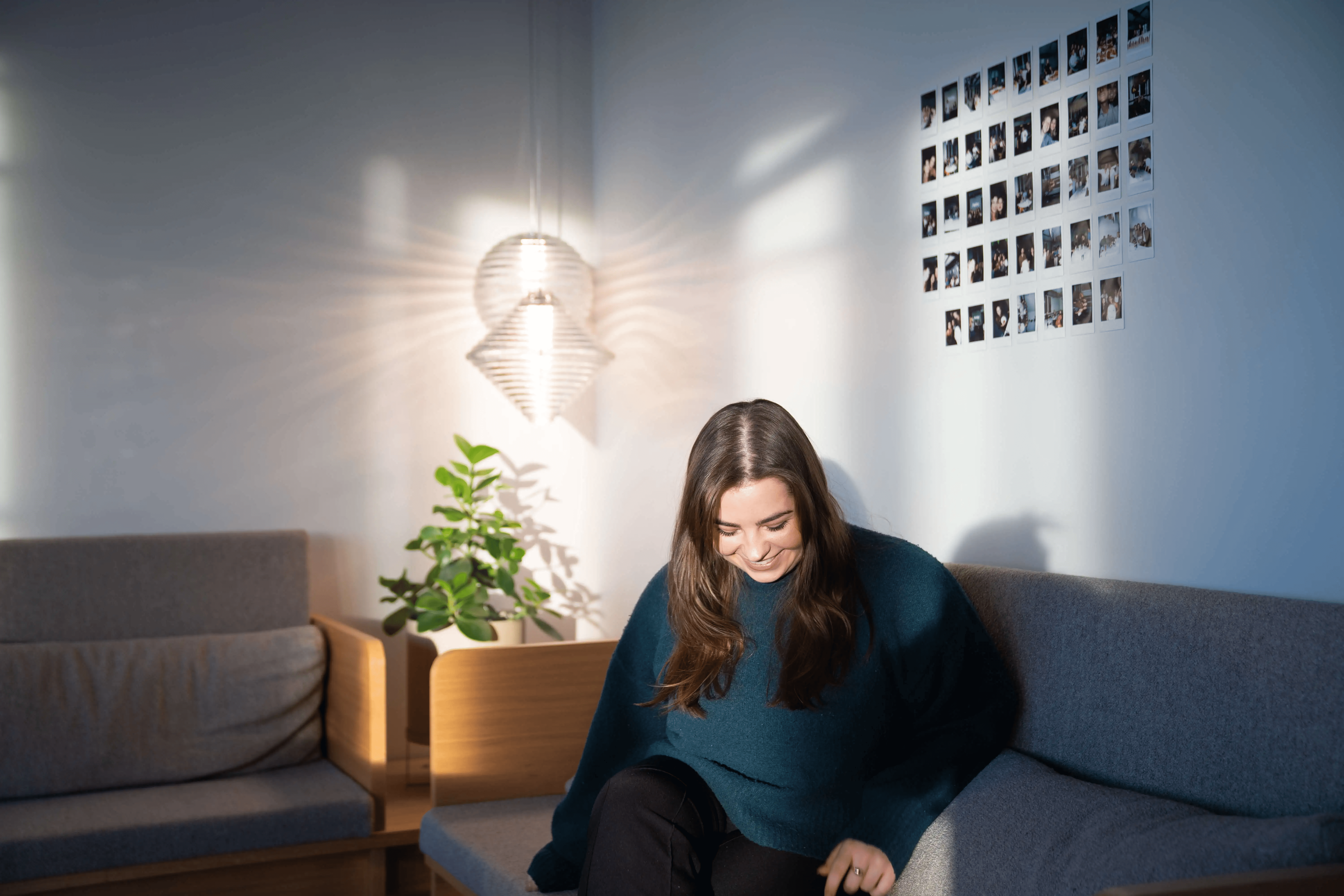 Woman sitting on an office couch with laptop for hiring visuals in flexible workplaces