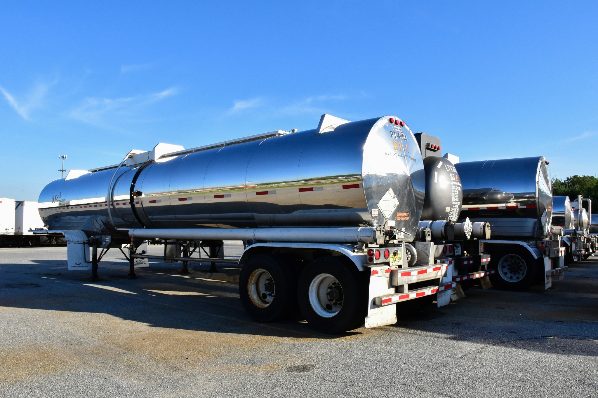 high resolution photo of chrome truck loading fuel tanks parked in a shipping company parking lot