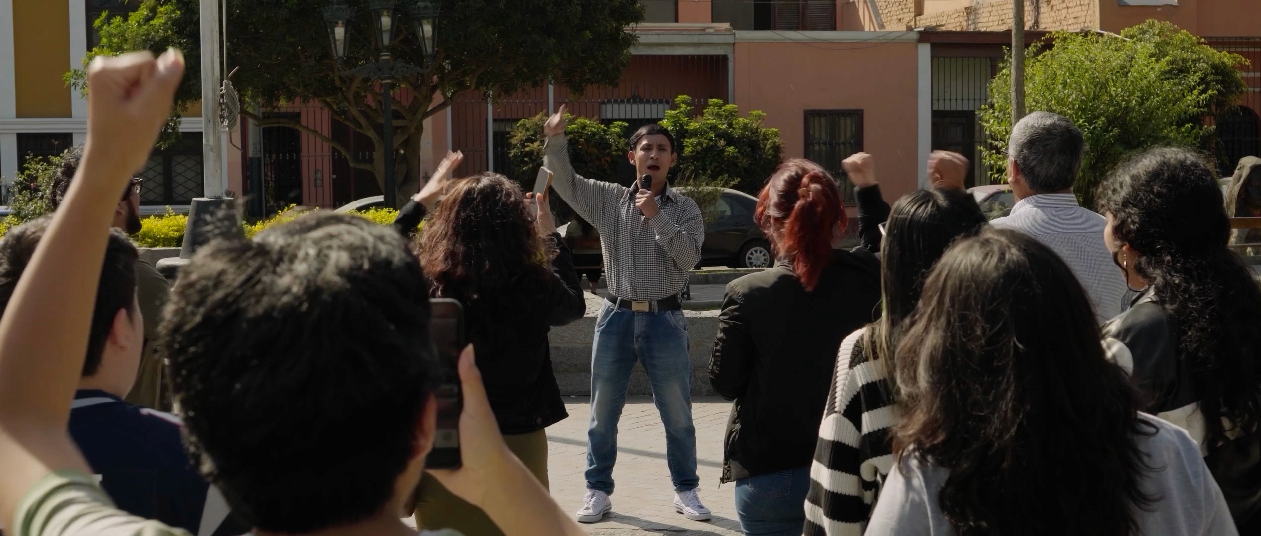 Woman in a light suit sitting thoughtfully against a terracotta wall