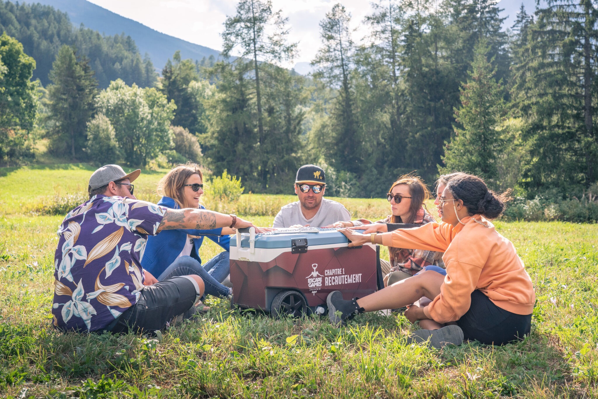 Groupe d'amis assis dans la nature autour d'un plateau de jeu