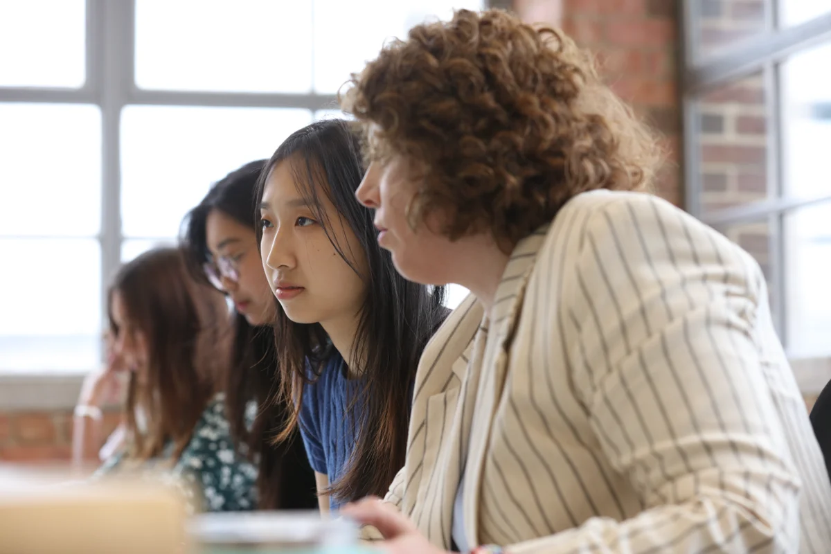 Professionals listening attentively during a collaborative team meeting in a modern open-plan office workspace.