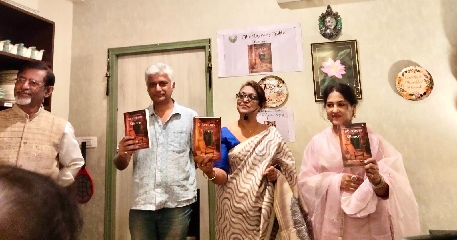 Aloka Dasgupta Niyogi and others holding copies of her debut novel, 'Inheritors of Silence,' at a book launch event.