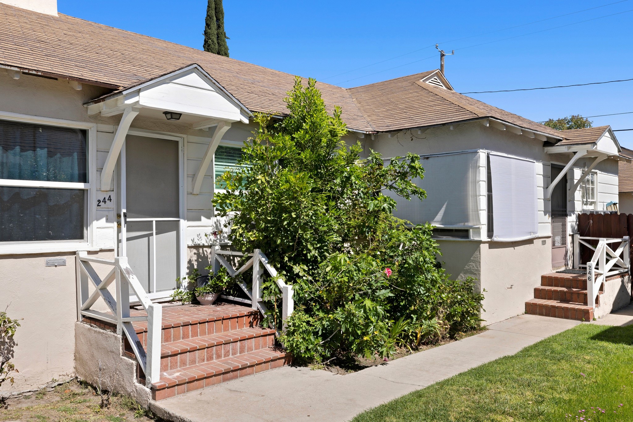 Close-up of front entry porches with brick steps and greenery at 242 N Cordova duplex in Burbank.