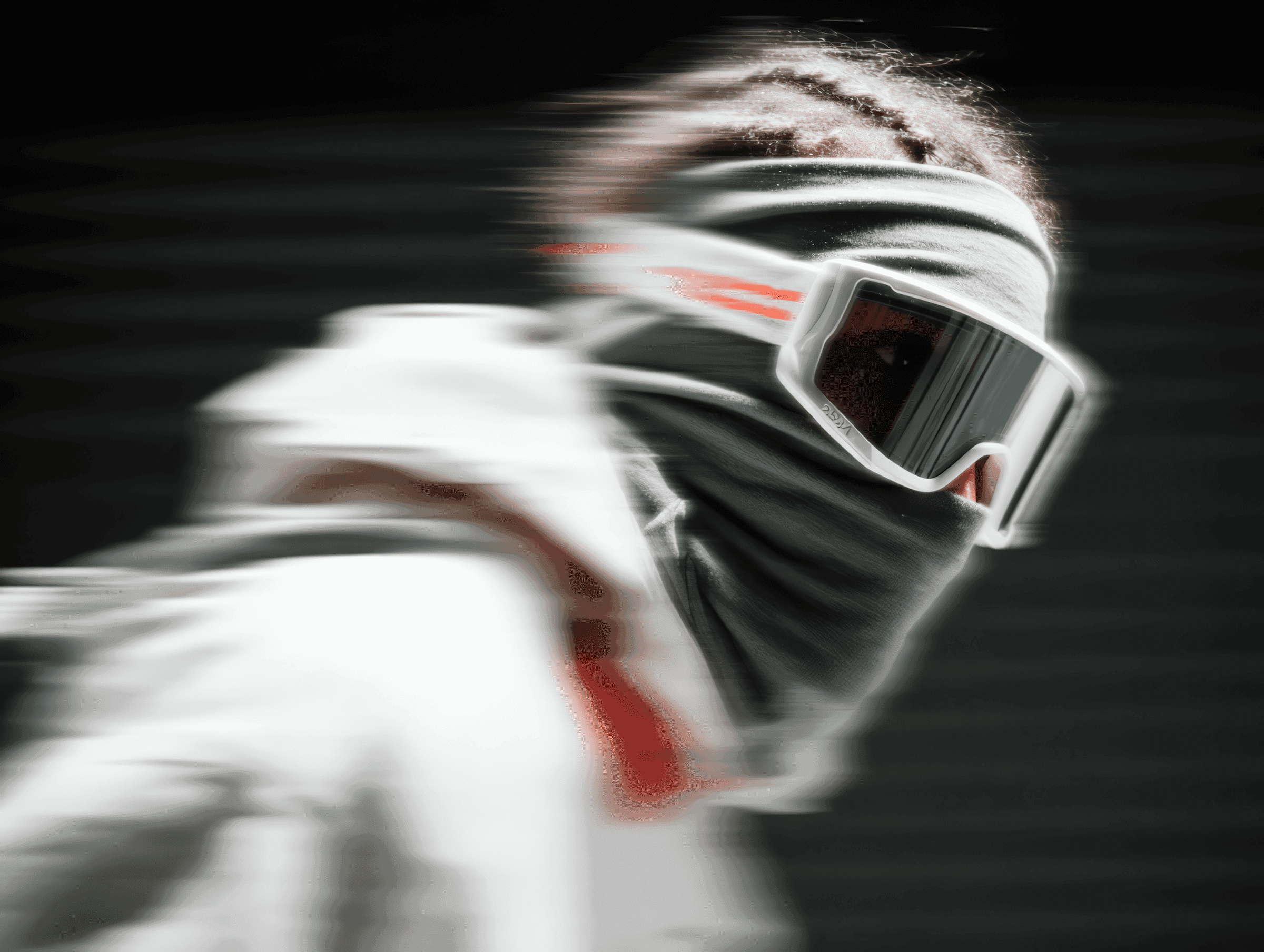 Side portrait of a person in goggles and face covering against a dark backdrop