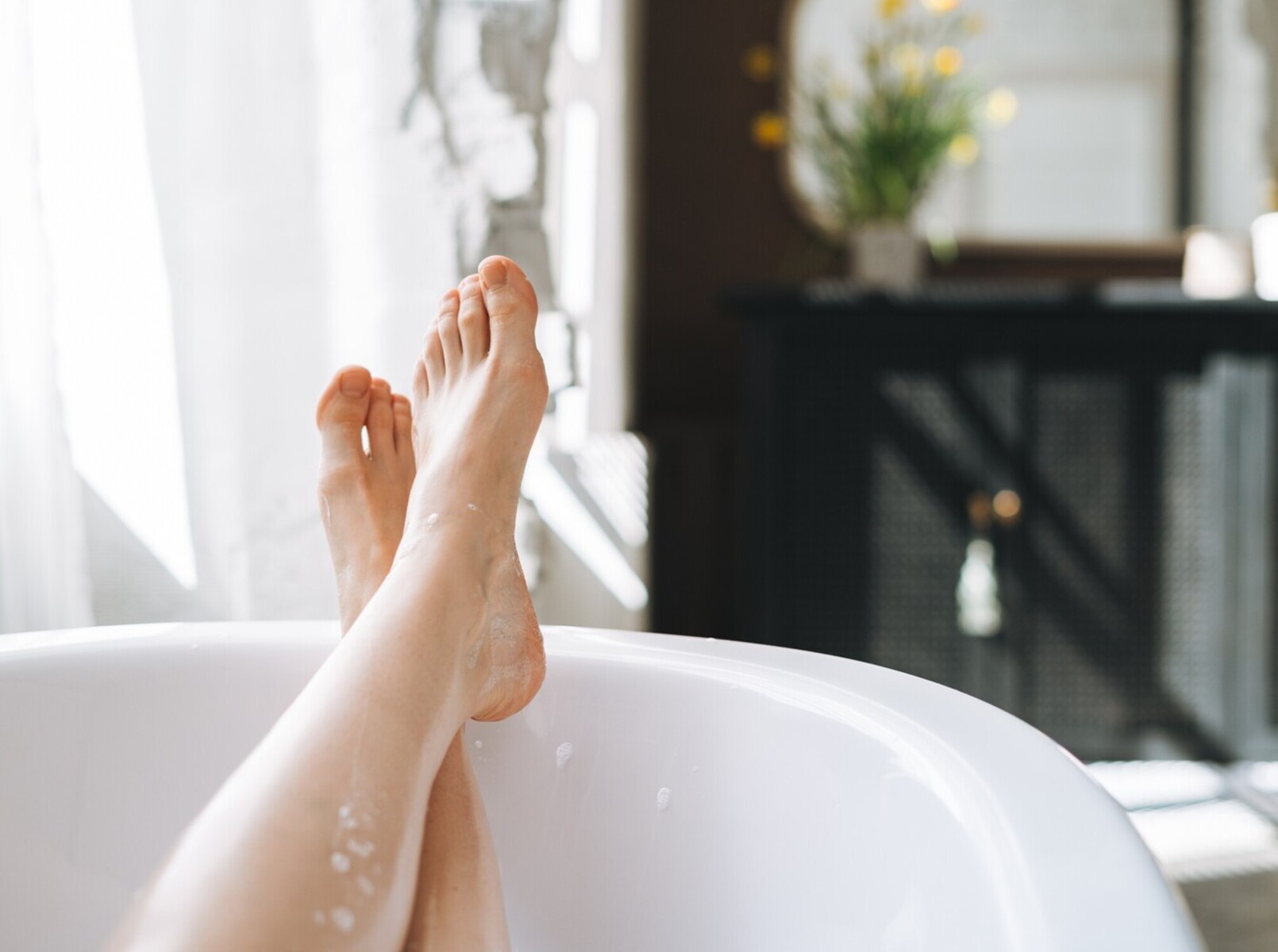 person sitting in an Epsom bath for too long, showcasing a sweating for weight loss myth