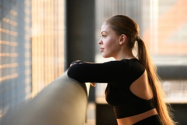 Woman stretching indoors with a vitamin insight card overlay