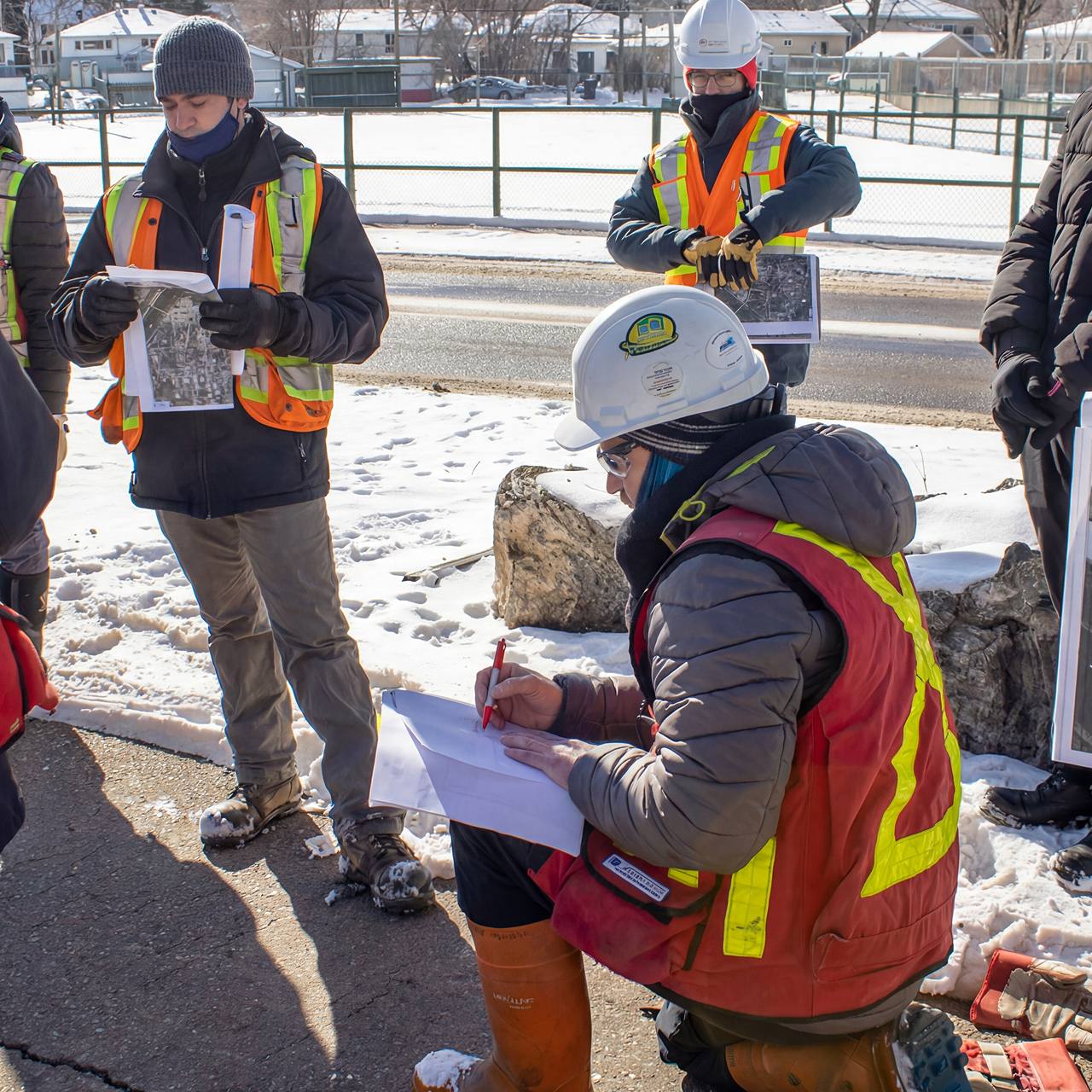 West Nose Creek channel realignment construction at sunset in northwest Calgary showing newly formed waterway with erosion control, survey markers, and crew conducting channel activation work