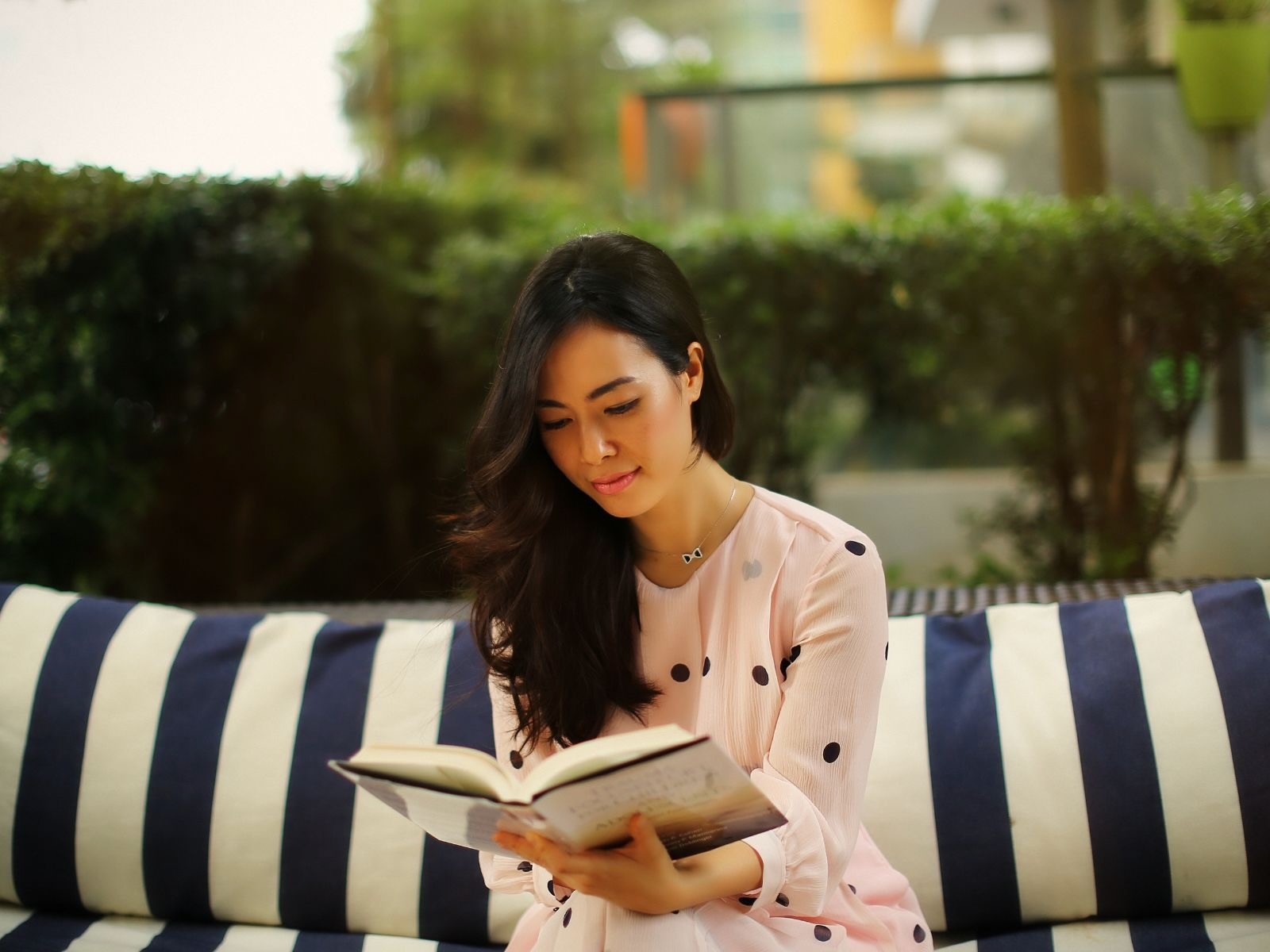 Huong Tran, MSMFT, a California-trained Marriage and Family Therapist in Ho Chi Minh City (HCMC). Huong is pictured reading outdoors, providing professional, evidence-based therapy for individuals and couples in Vietnam.