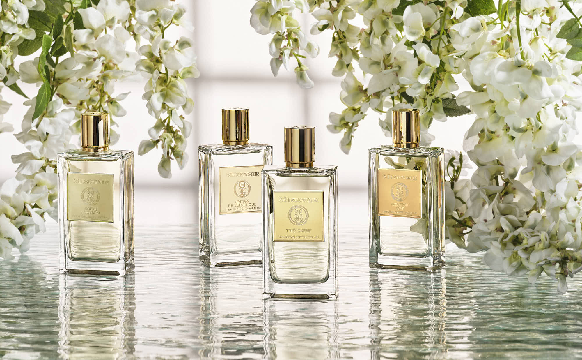 Luxury perfume bottles surrounded by elegant white flowers.