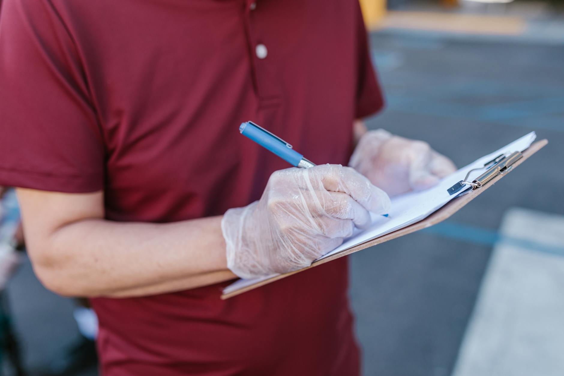 A teacher uses a tablet to check off items on a printed inventory list of classroom laptops and tablets.