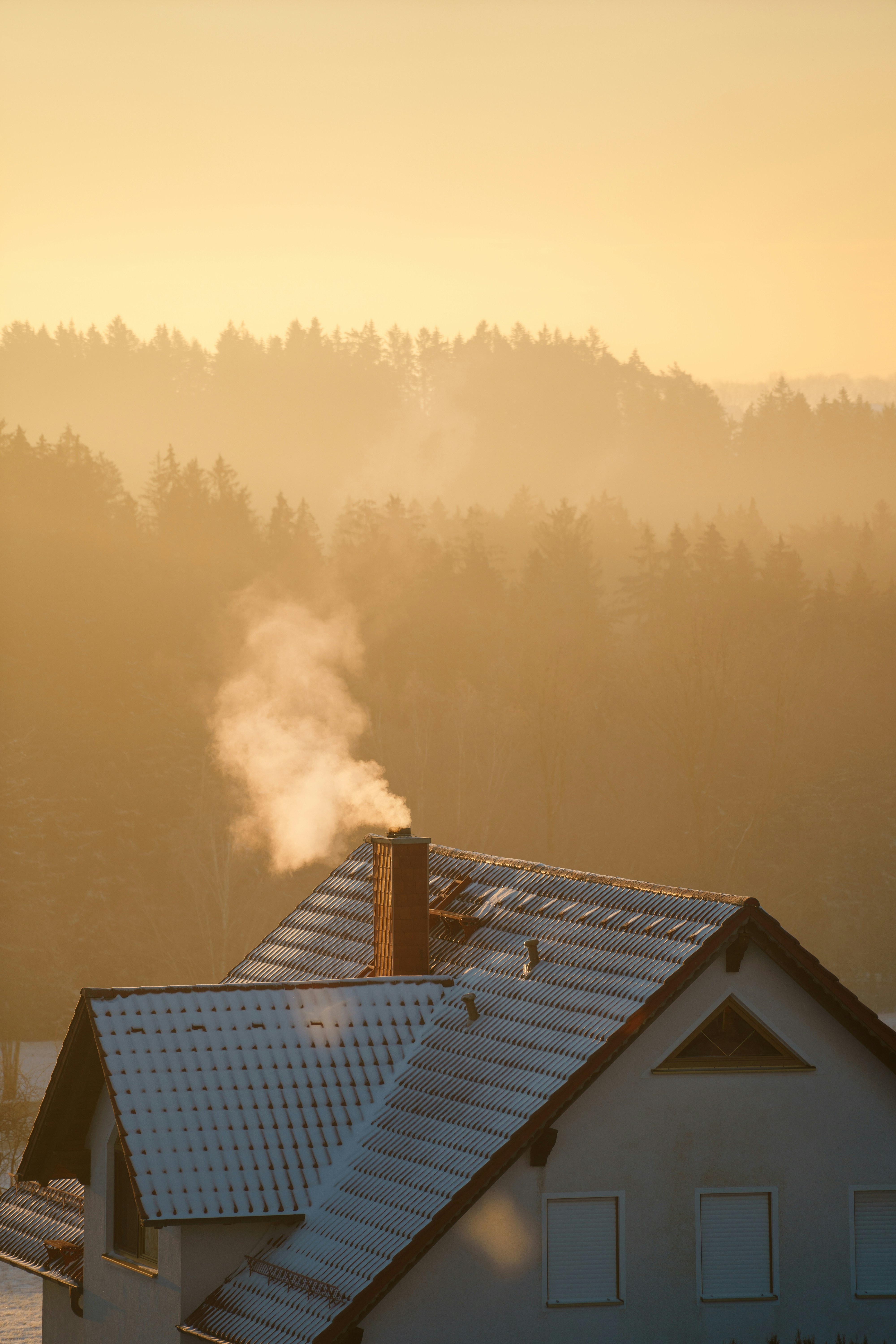 smoke coming out of a chimney on top of a house
