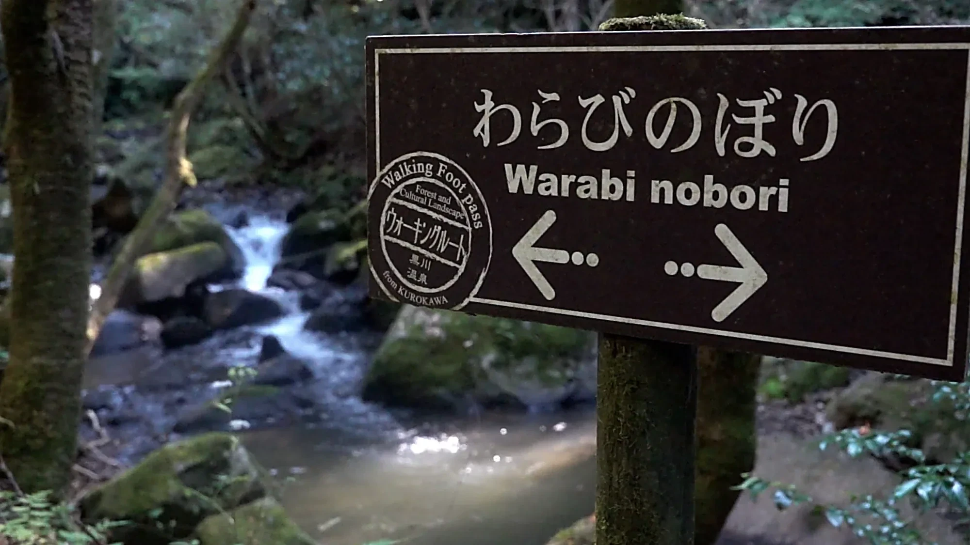 The Warabi-nobori walking-trail sign at Kurokawa Onsen with directional arrows