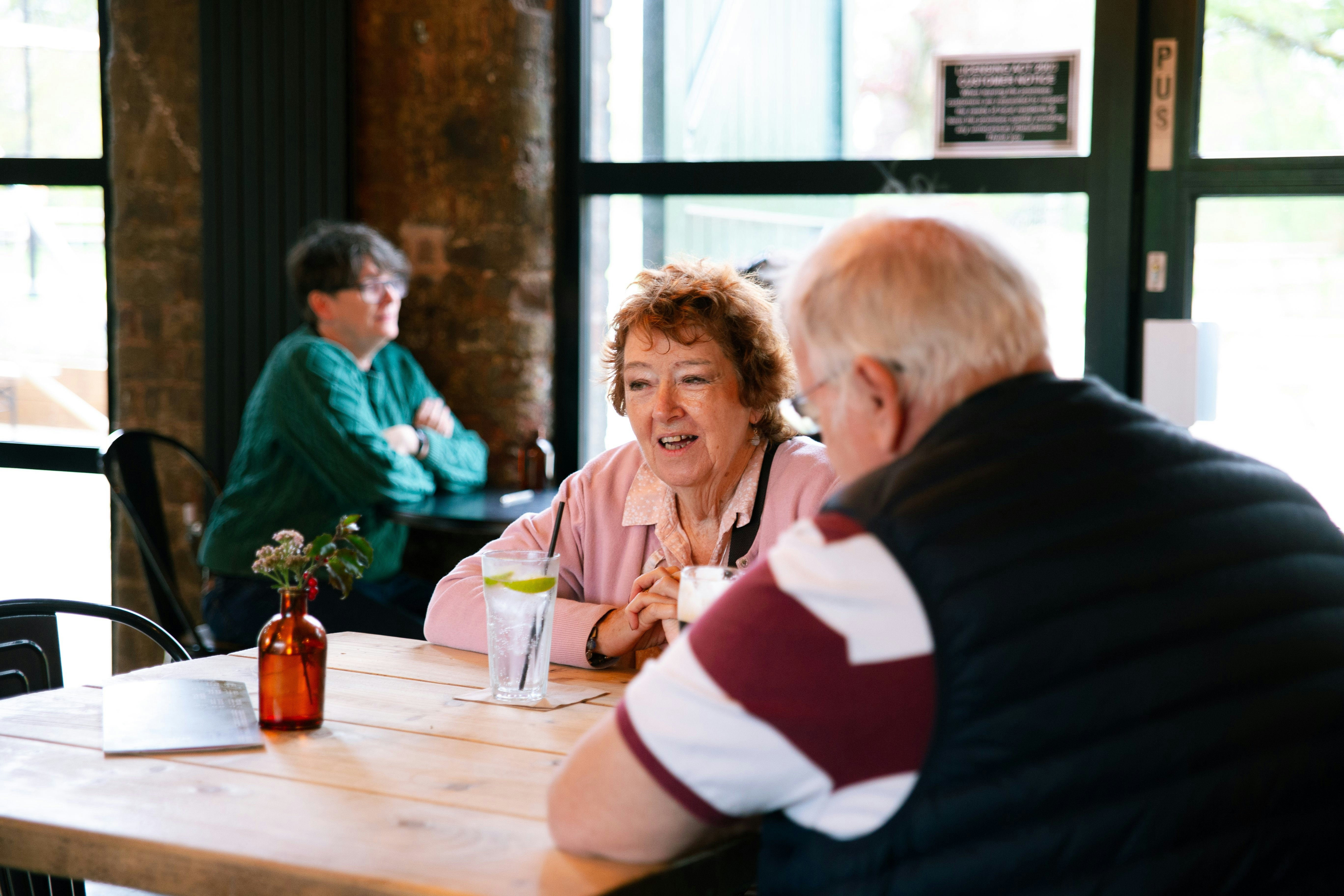 Two couples talking at a table in a cafe.