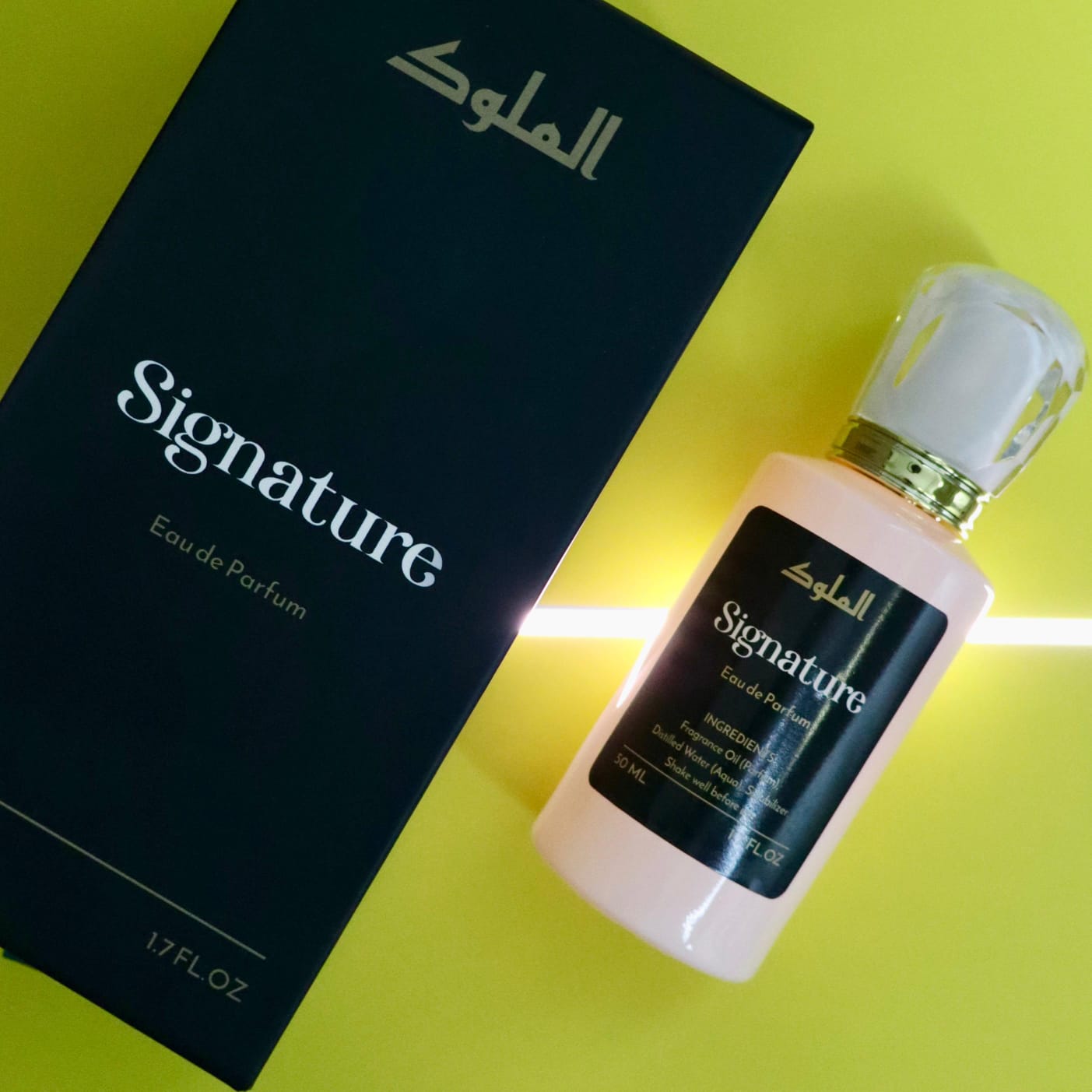 Signature perfume bottle and dark green box with gold typography styled against a vibrant lime backdrop with dramatic lighting.