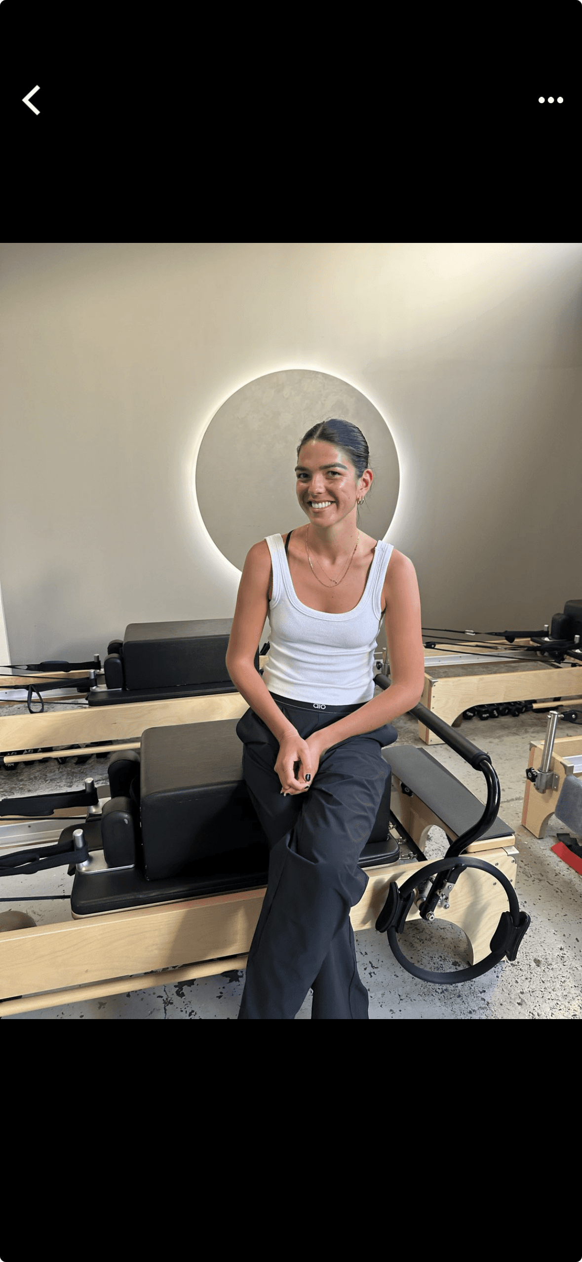 Black cosmetic product bottle against a dark background