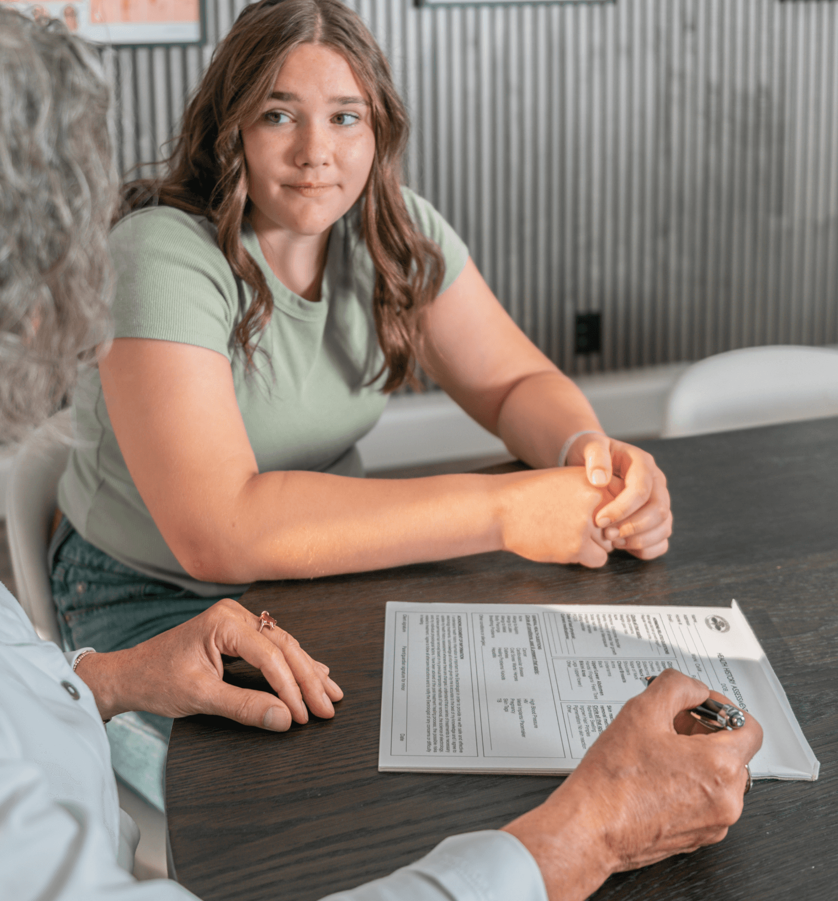 Client filling out a consultation form with an electrologist at the studio
