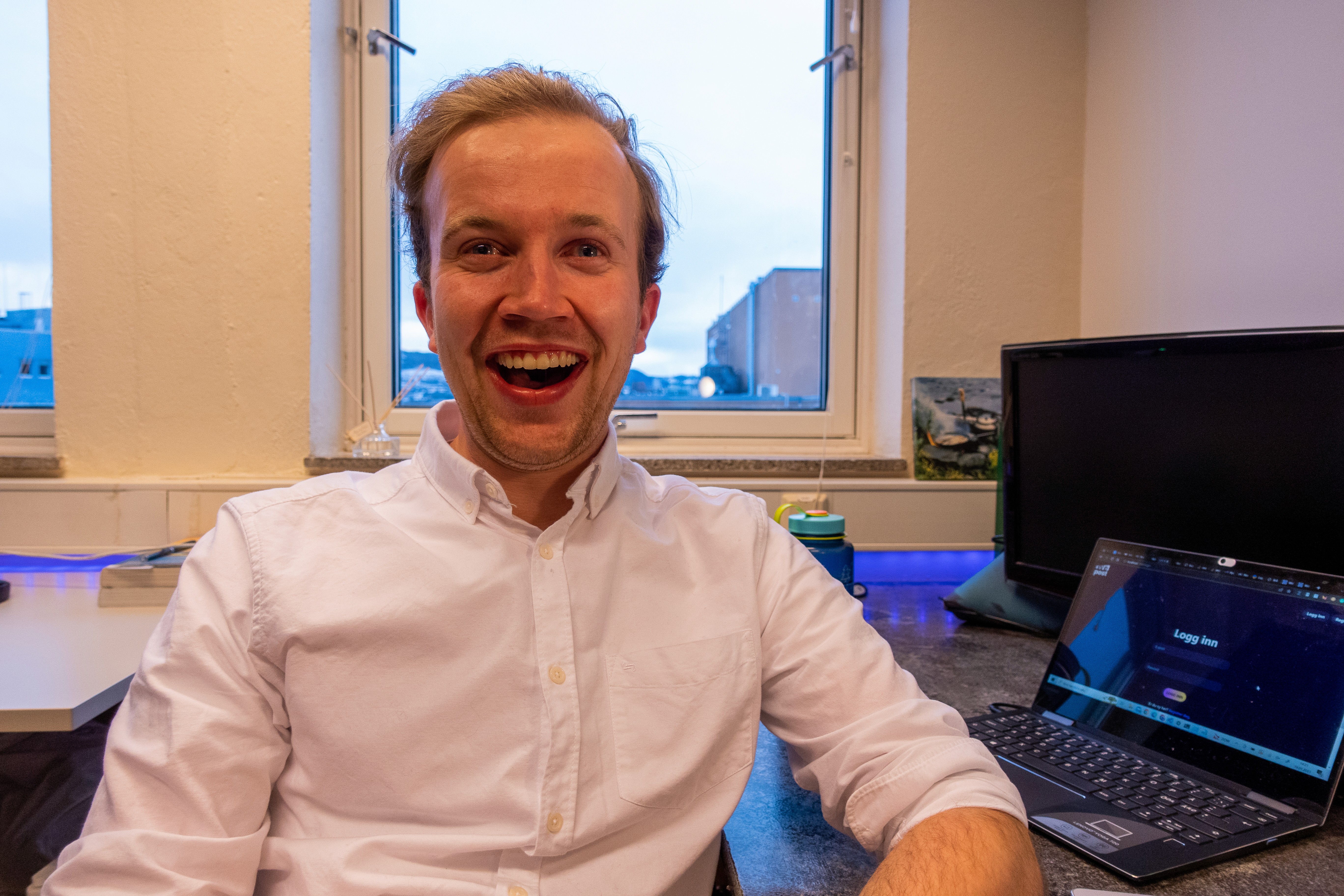 Close-up of a dark green leaf showing its textured surface and central vein against a muted background.
