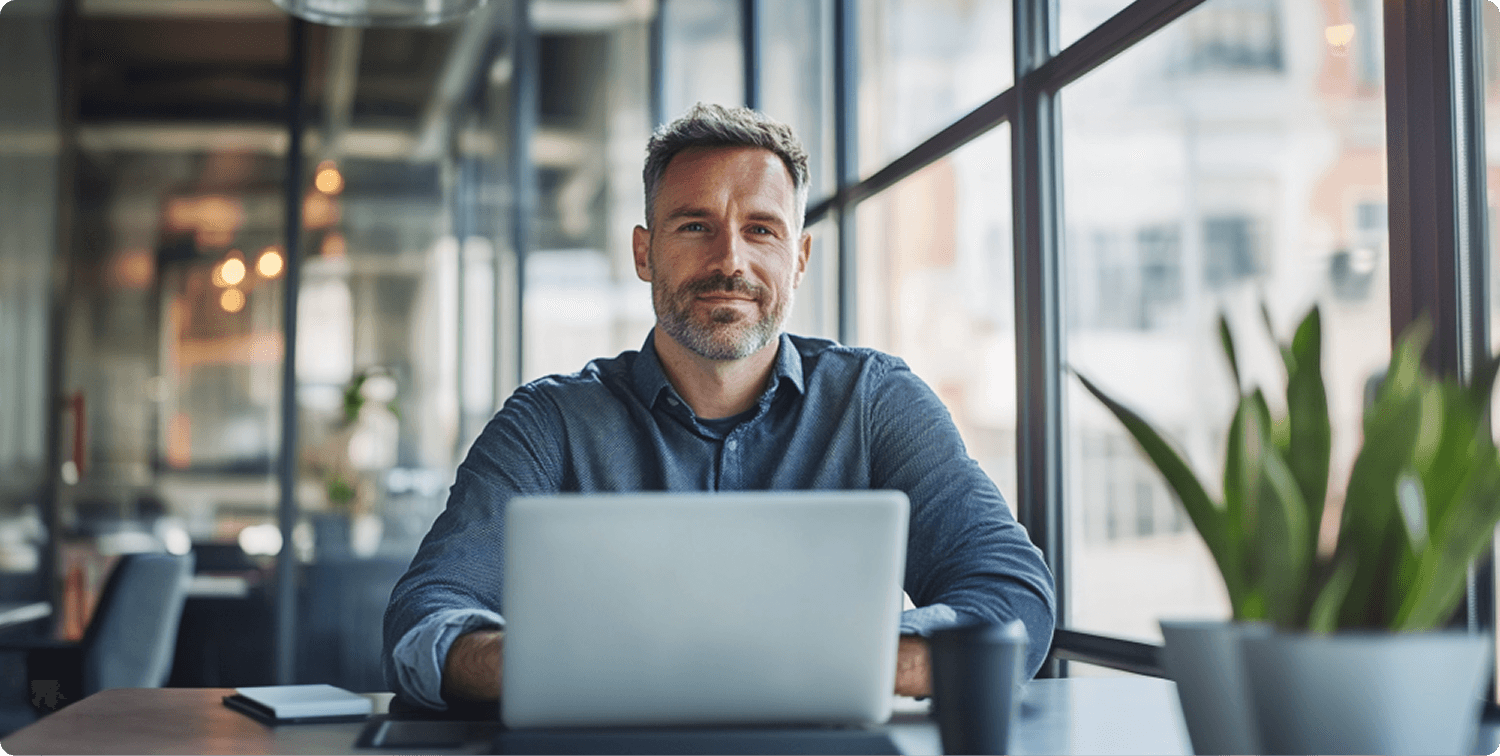 A man in a red vest is talking to a woman with long brown hair in a bright, modern space.