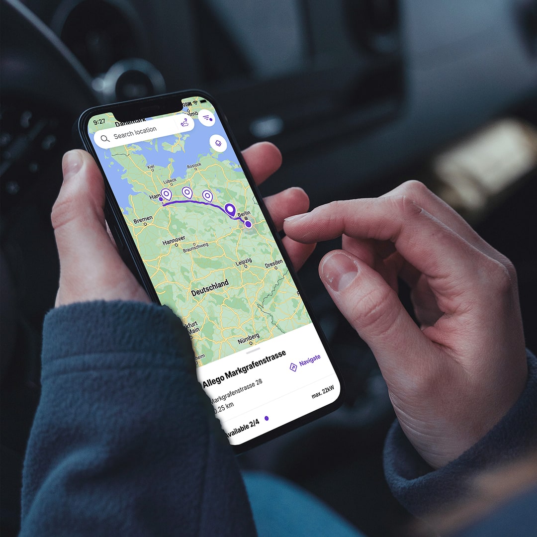 Person holding smartphone displaying Elli app map with charging station locations across Germany