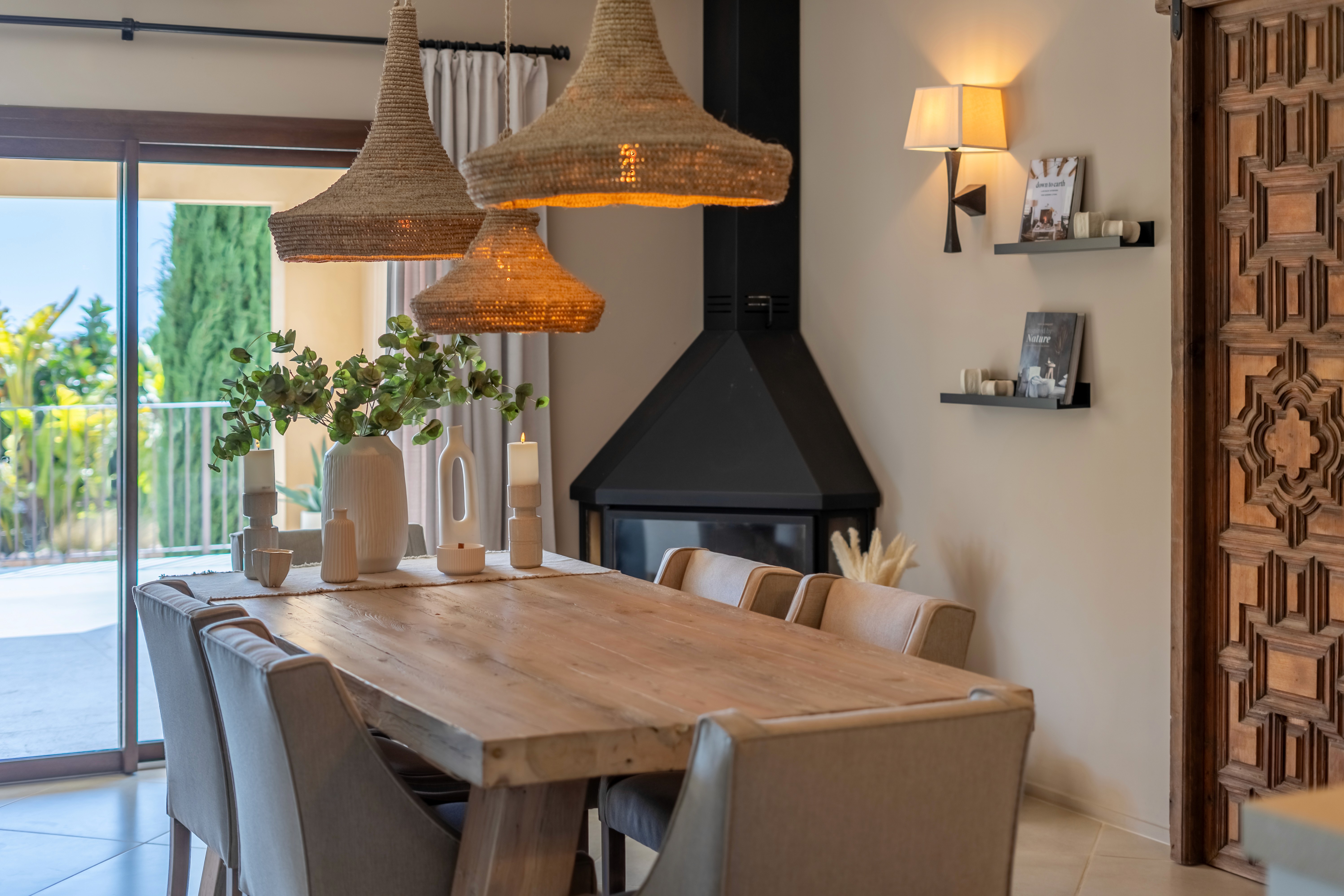 Essbereich der Finca in Llucmajor mit Holztisch, Kamin und warmem, mediterranem Interior Design