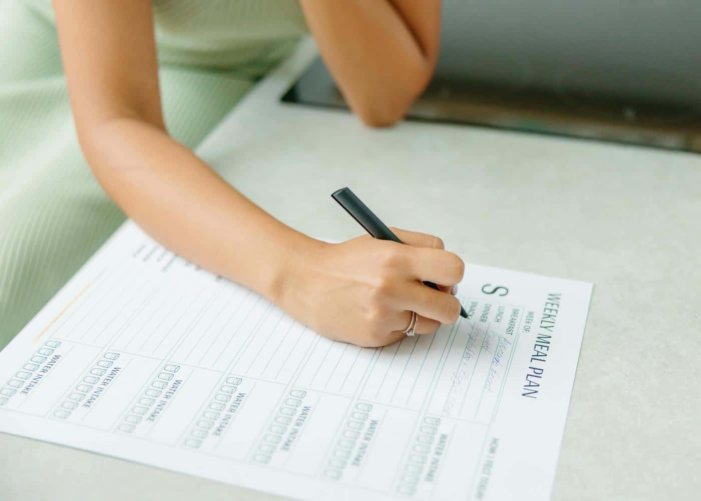 Woman filling out an AI diet plan with a pen