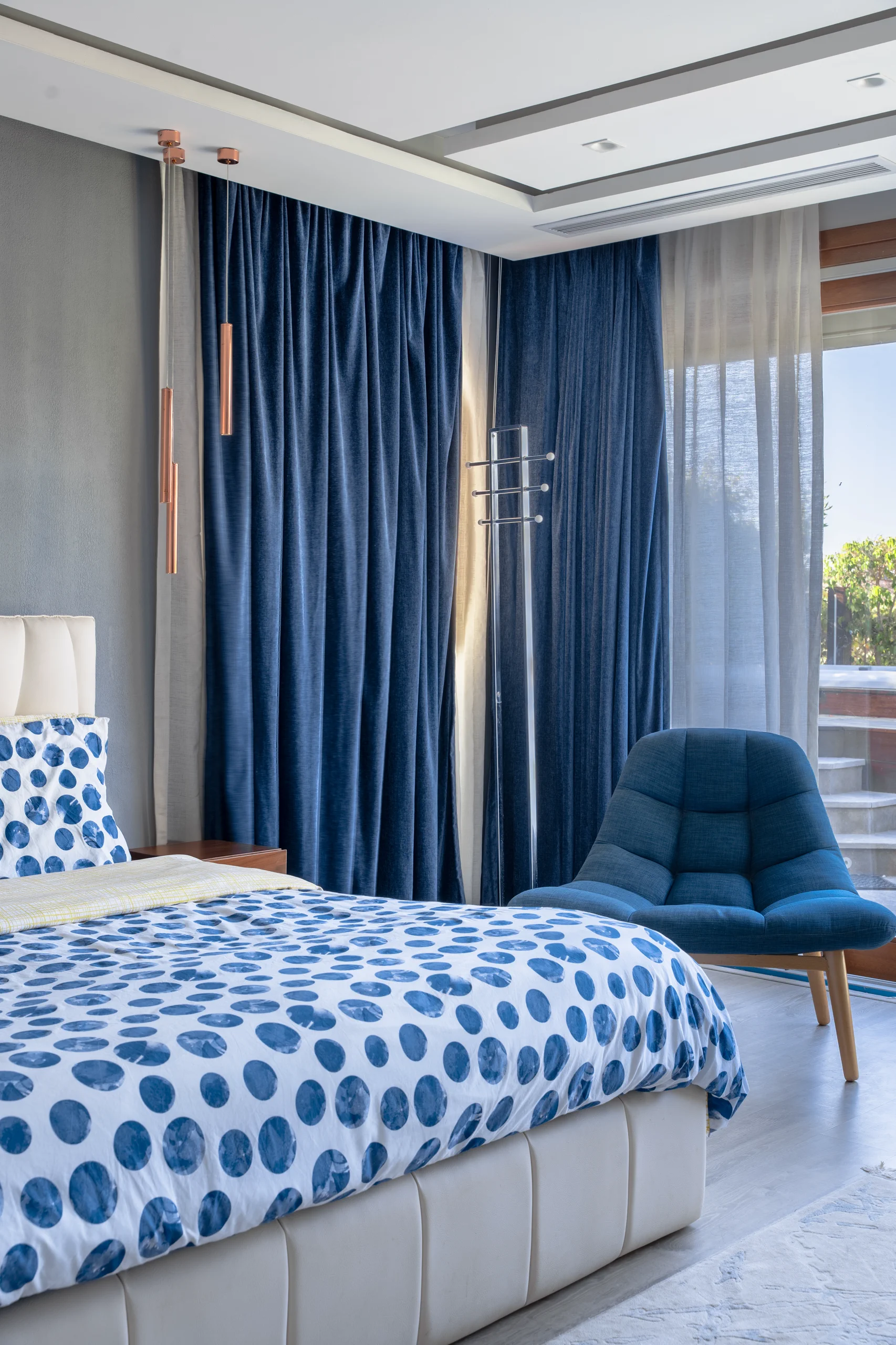 Bedroom view at Caesar SODIC Villa with tailored blue textiles and contemporary furniture.