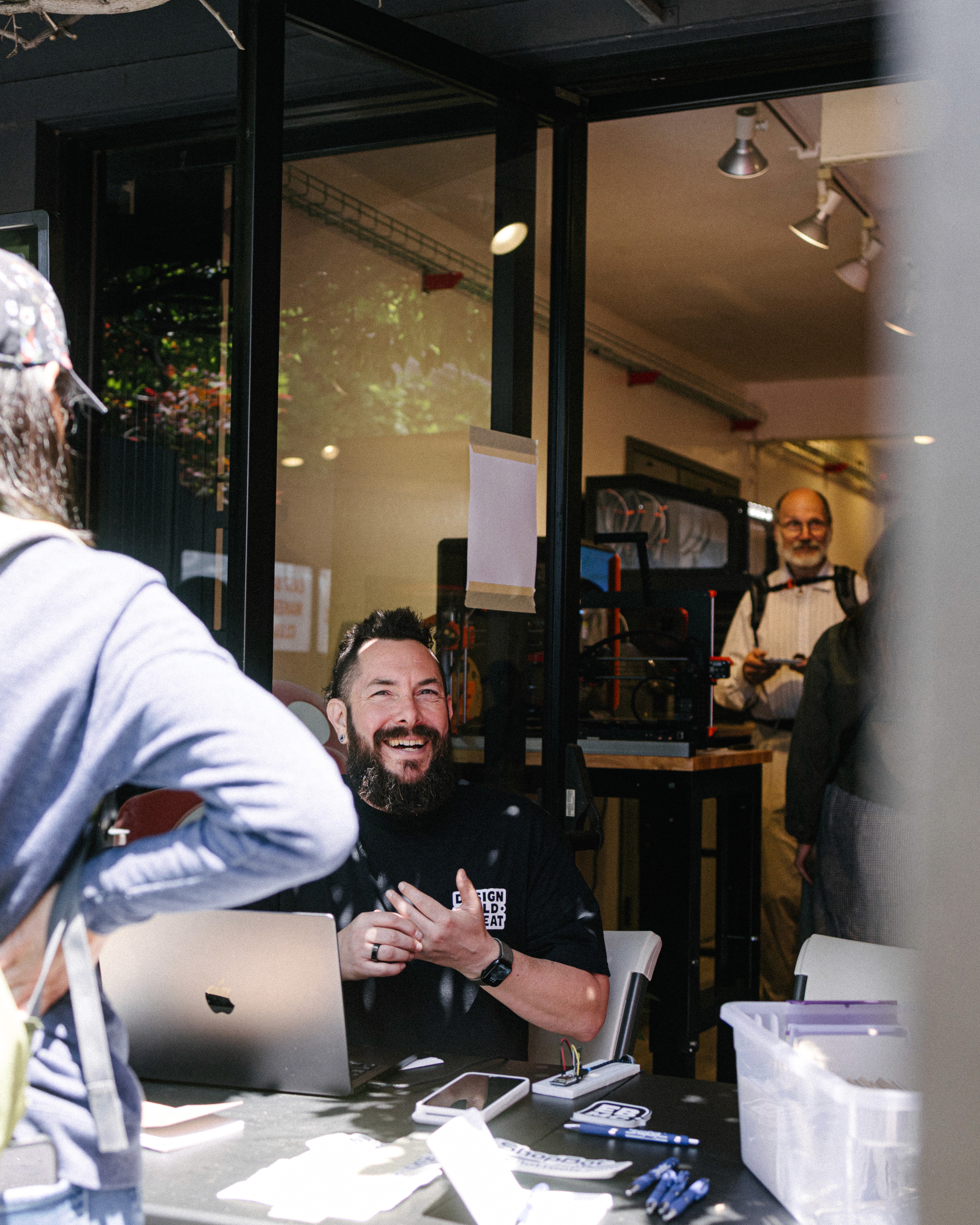 THE FOUNDER OF EAST BAY MAKERS CLUB SMILING WHILE SIGNING PEOPLE UP