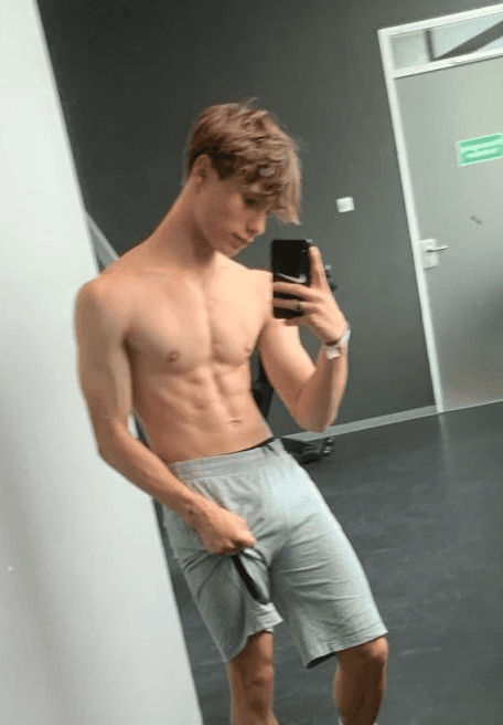 greyscale photo of woman in bralette inside room