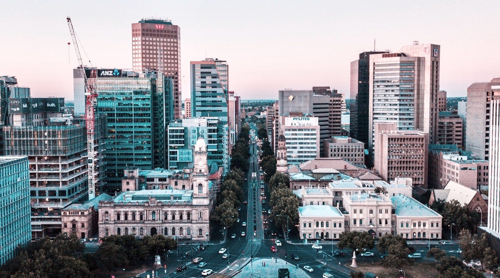 City skyline with a wide street lined by trees