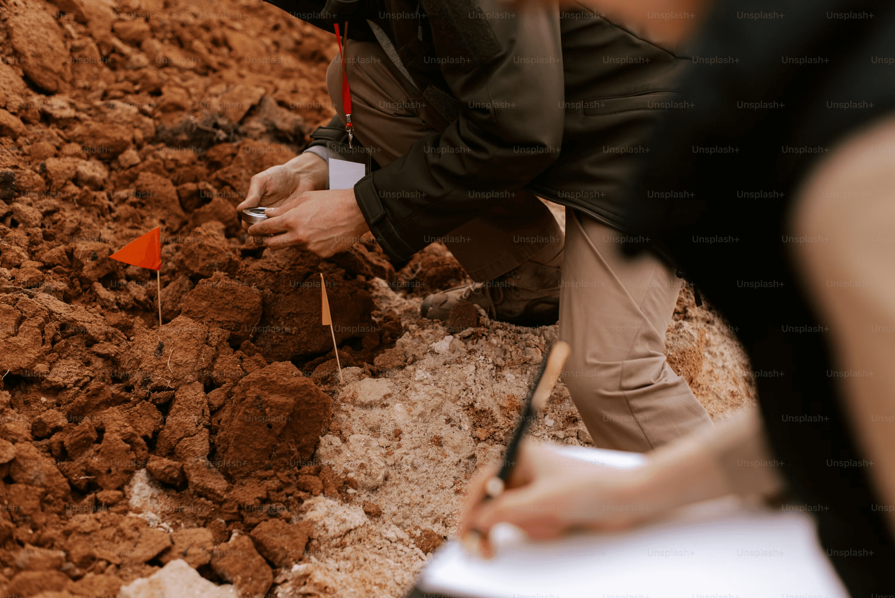 High school student examining archaeological artifacts alongside a PhD mentor in a university research setting
