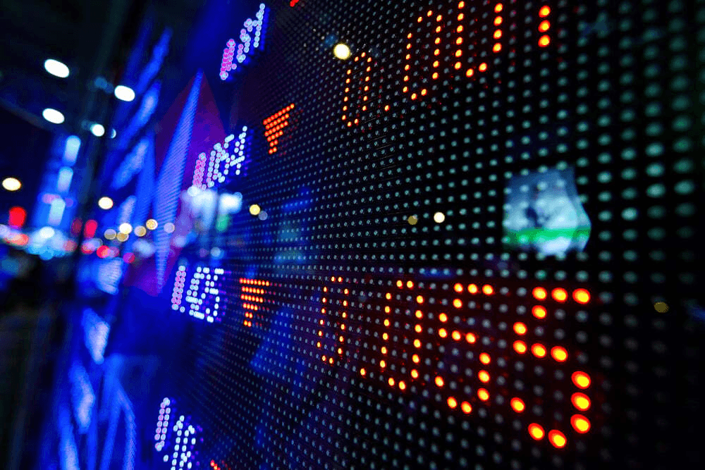 A colorful sign hanging on a wall with bright lights.