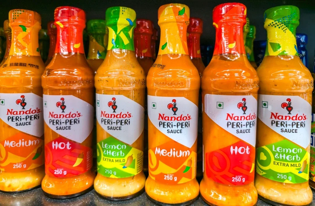 Bottles of nando's peri-peri sauce in various flavors.