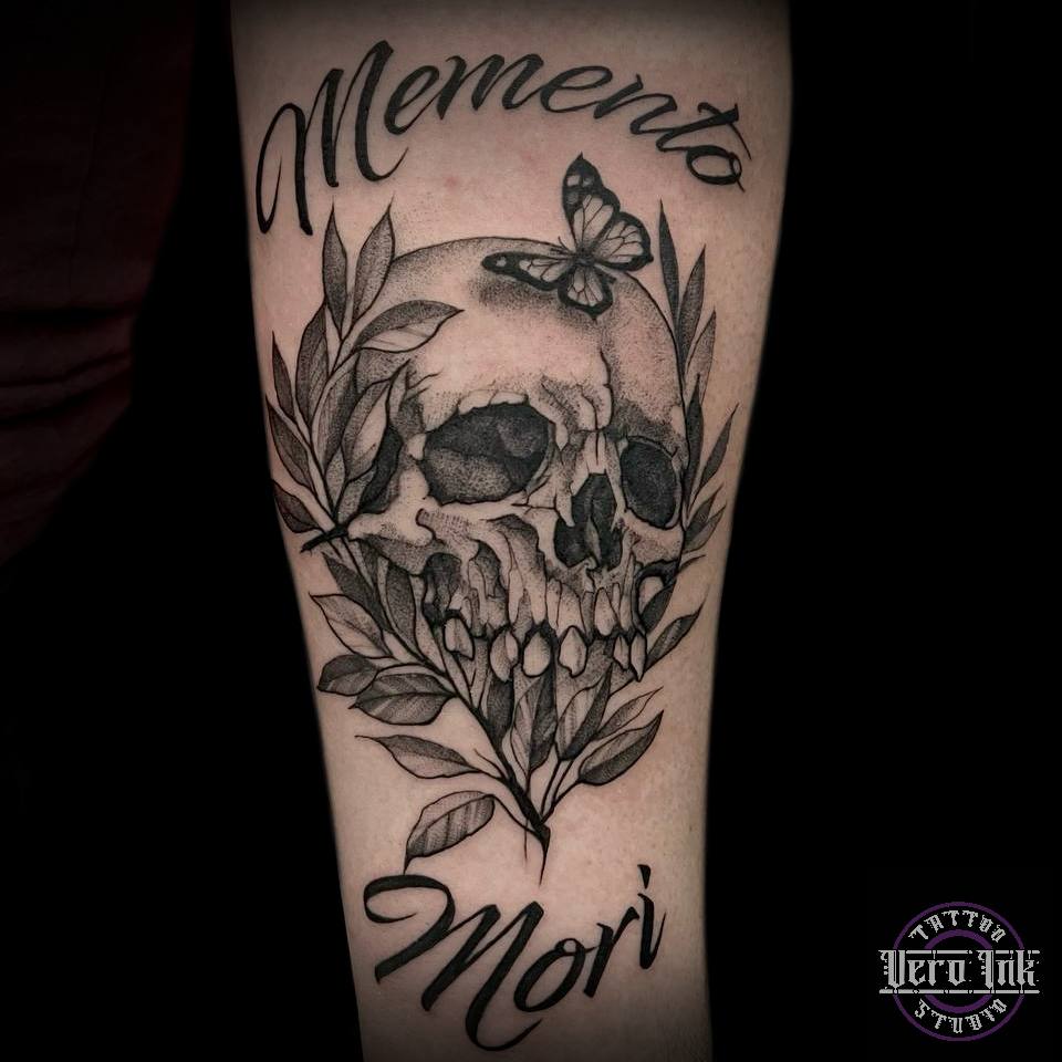Wytatuowana na przedramieniu ludzka czaszka z napisem memento mori.