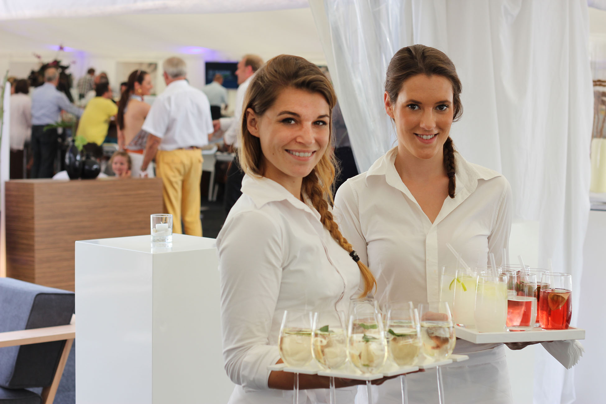 Servicekräfte mit Getränken im VIP-Bereich einer Sportveranstaltung