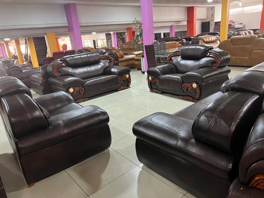 a gray couch with a wooden base on a gray background