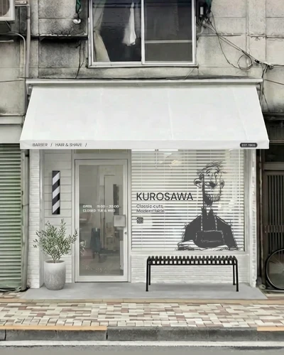 外観リブランディング提案後：白い庇とロゴ、窓グラフィックの理髪店外観