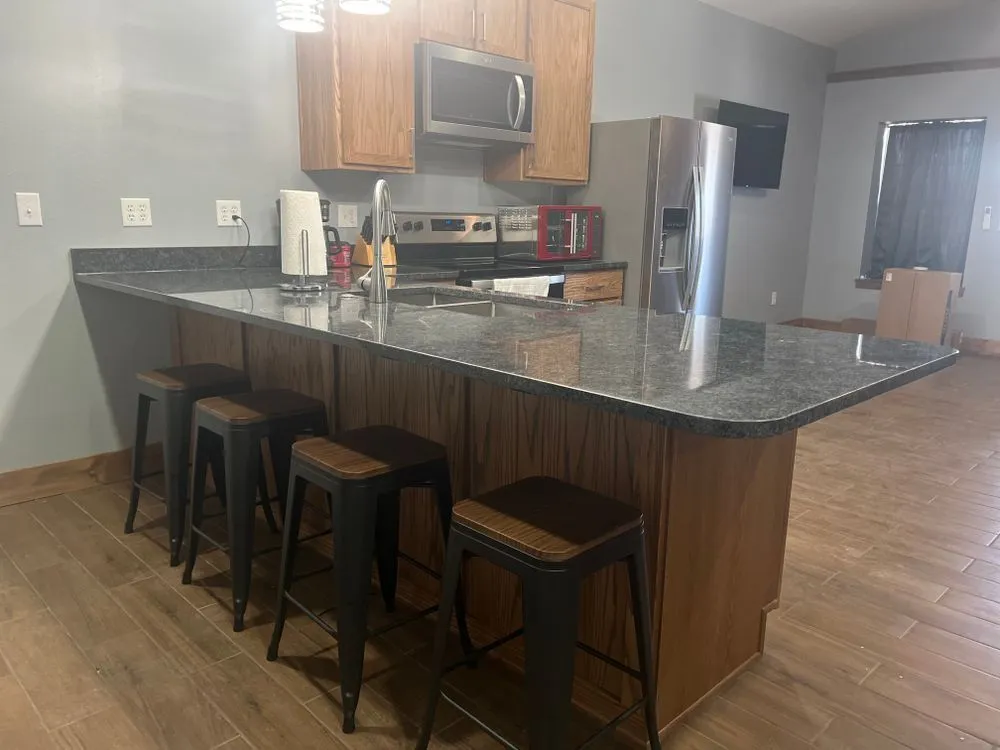 A kitchen bar with dark countertop