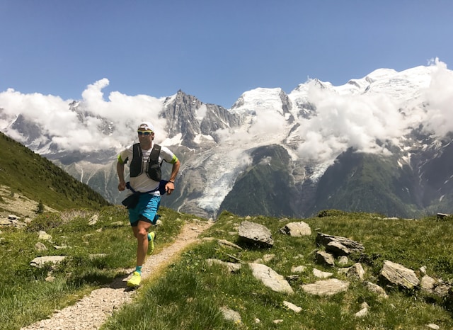 Trail runner moving through a mountain landscape with rocky peaks